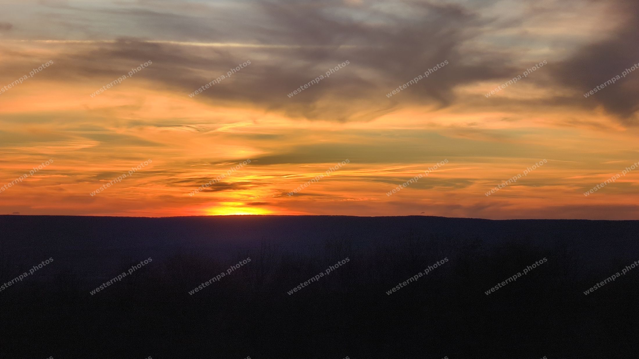 Orange sunset over a dark mountain ridge