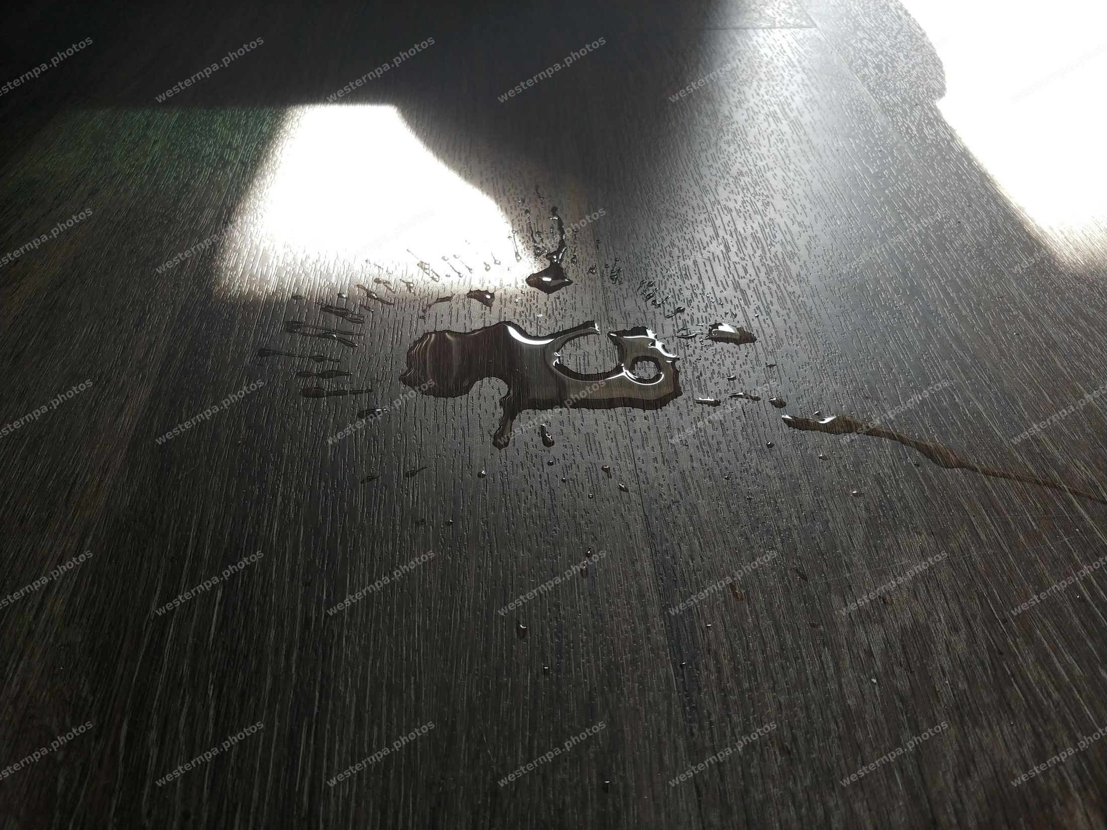 Water droplets and light on a dark wood surface